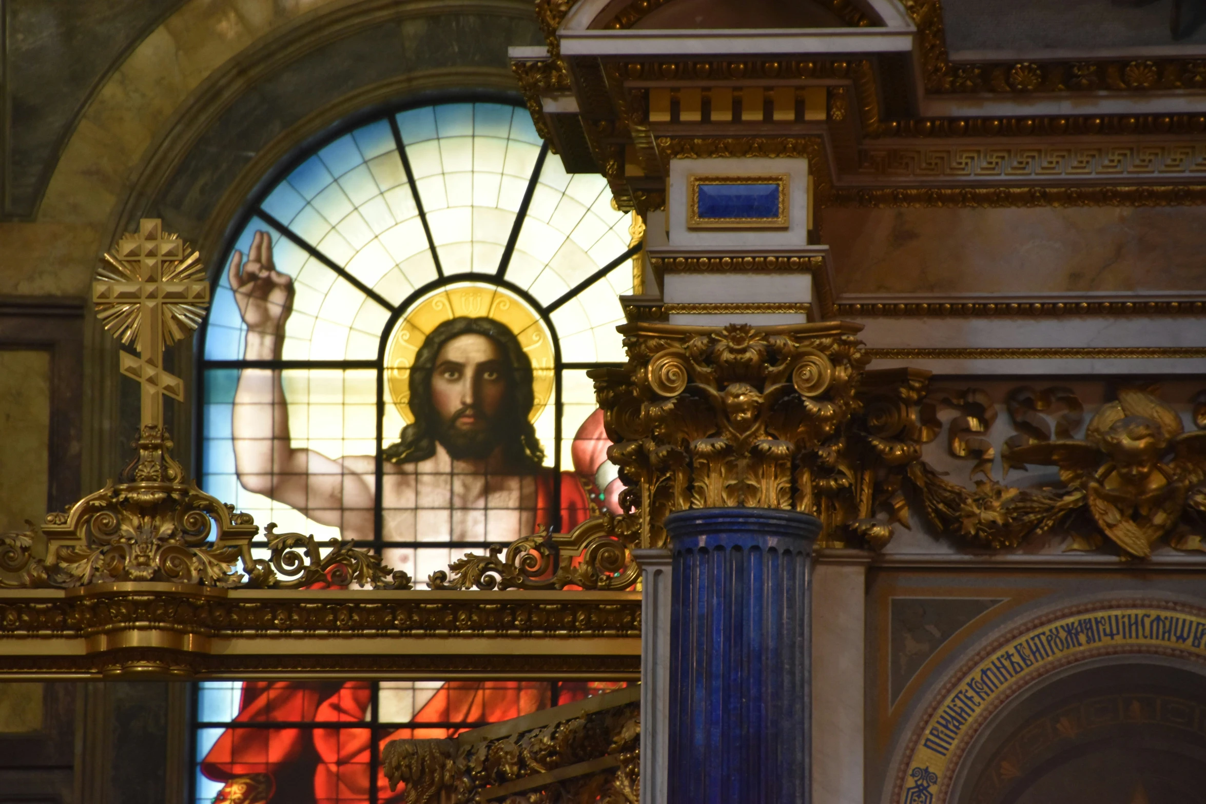 a stained glass window inside of a church with a statue in the center