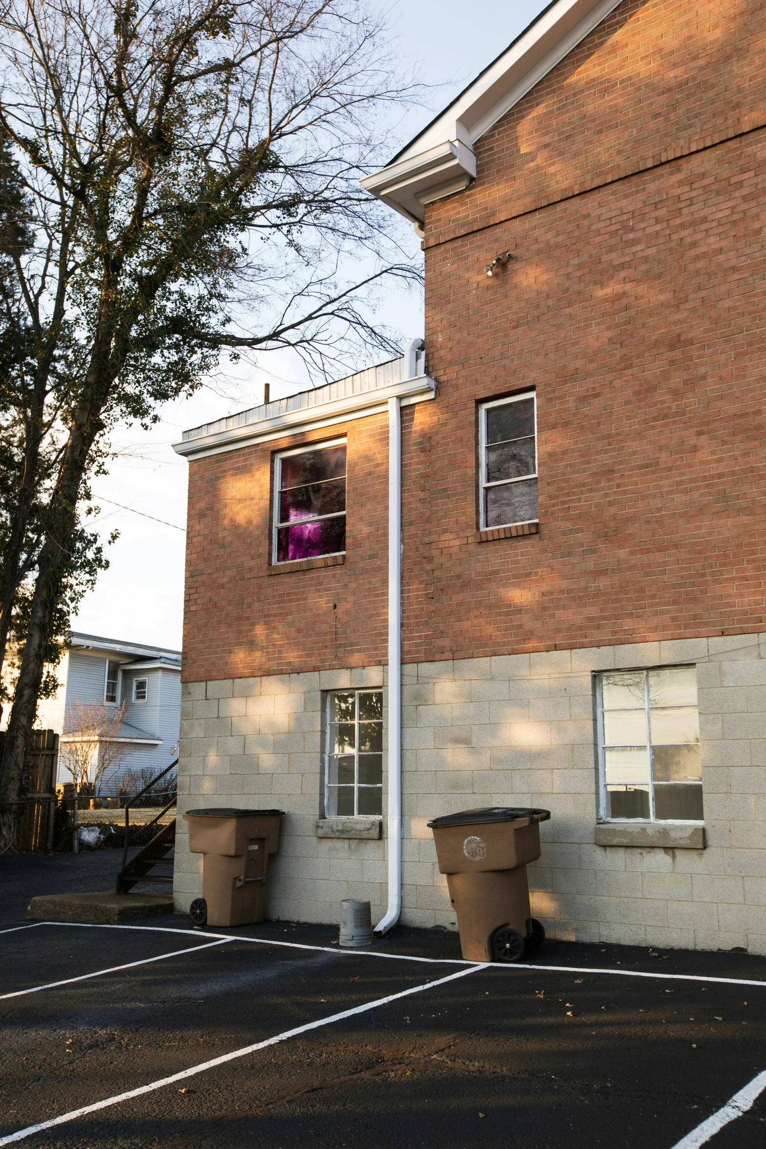 a brown building on a street corner with two benches in front of it