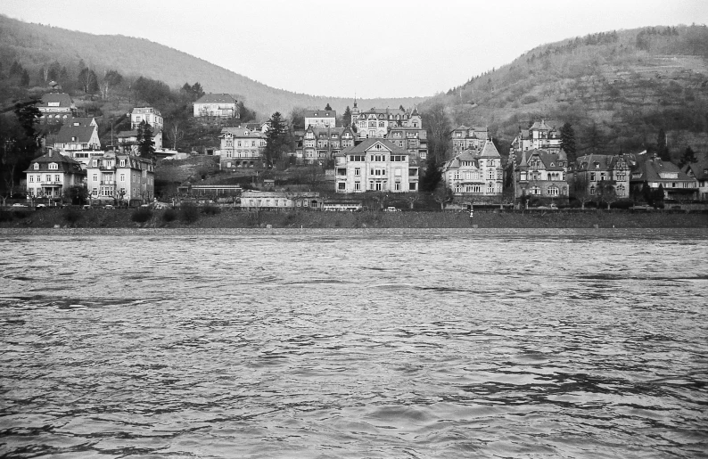 a black and white po with a city on the shore and a lake below