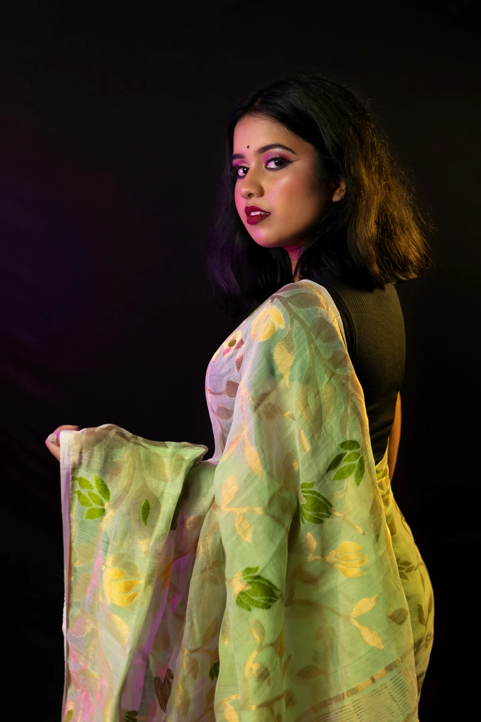 a beautiful young woman carrying a colorful yellow and green cloth
