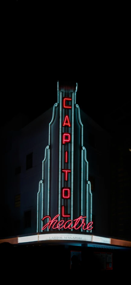 large neon sign with building in the background