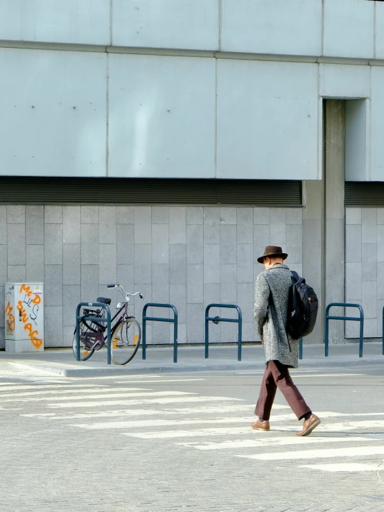 a man crossing the street with his back to the camera