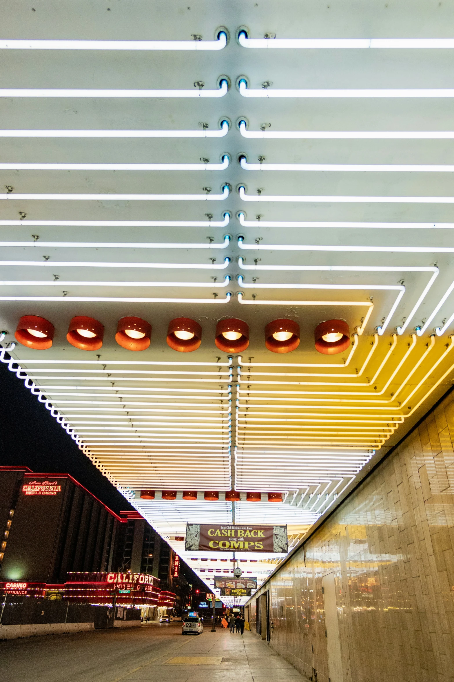 a parking garage with lights overhead and people walking