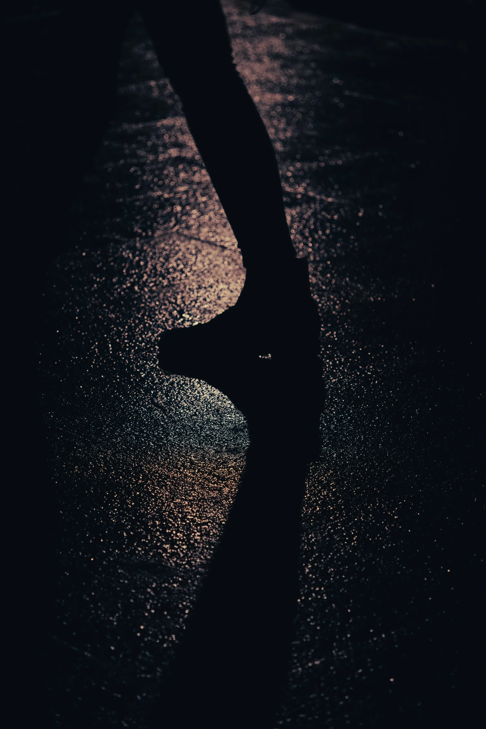 a person walking on a dark street in the rain