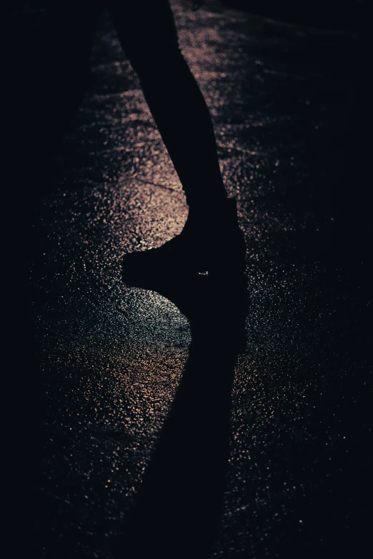 a person walking on a dark street in the rain