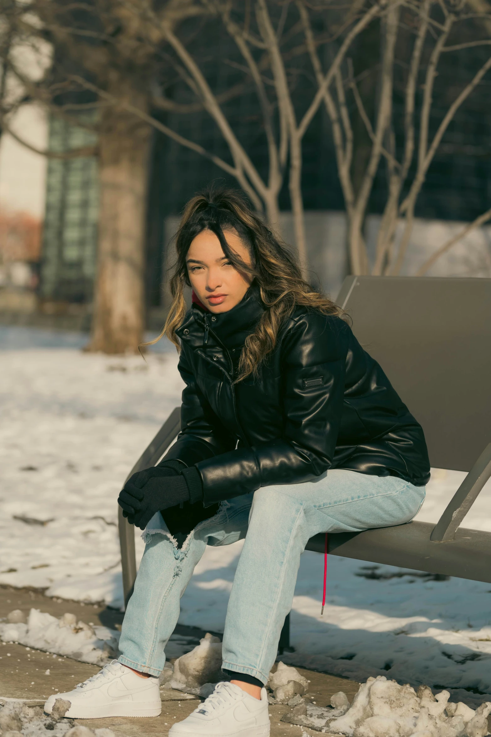 a woman sitting on a bench in the snow