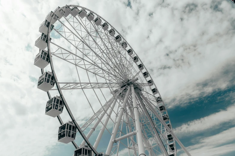 a ferris wheel is in the cloudy sky