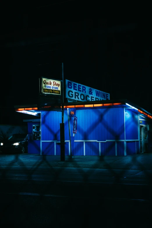 the building on the side of the road is lit up blue