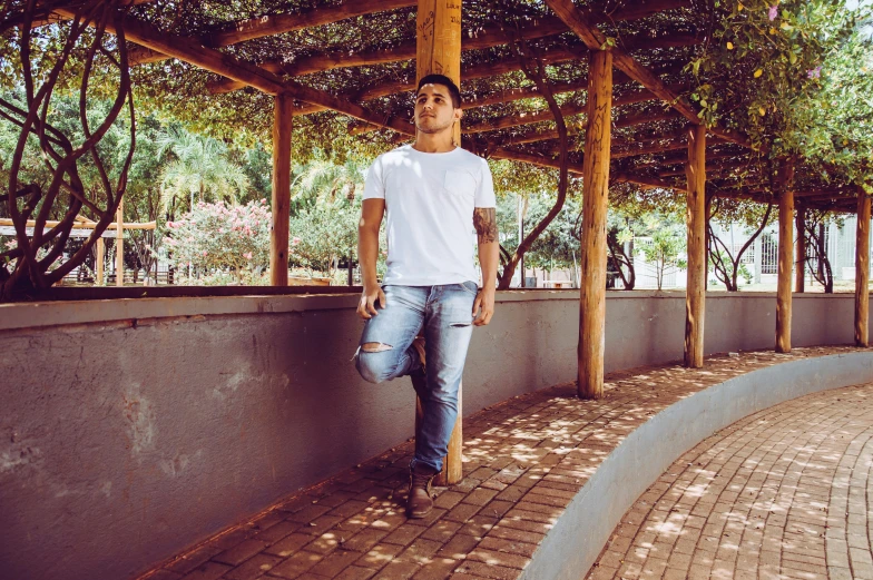 a guy is standing in front of some trees and bushes