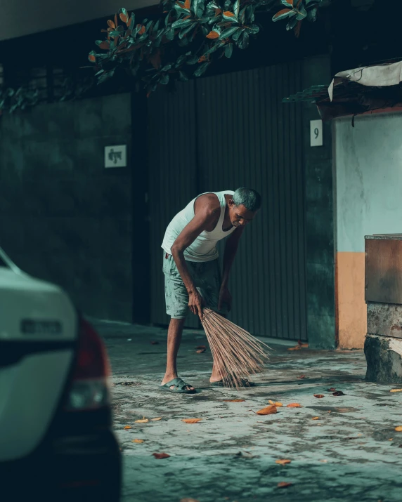 the man is sweeping the pavement with a broom