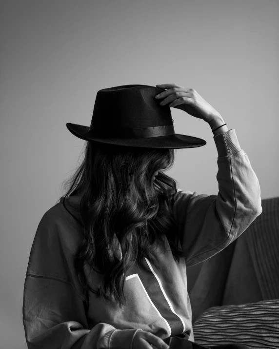 a black and white po of a person wearing a hat