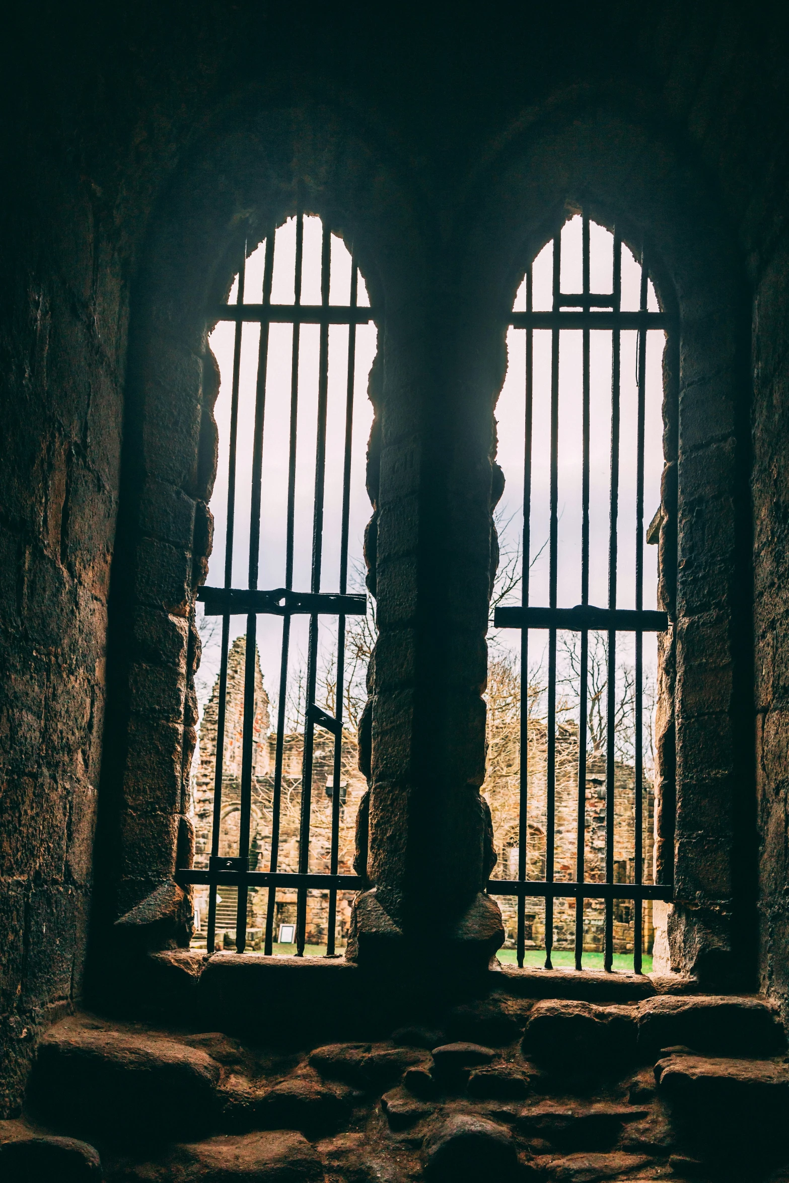 a large open barred window in an old stone building