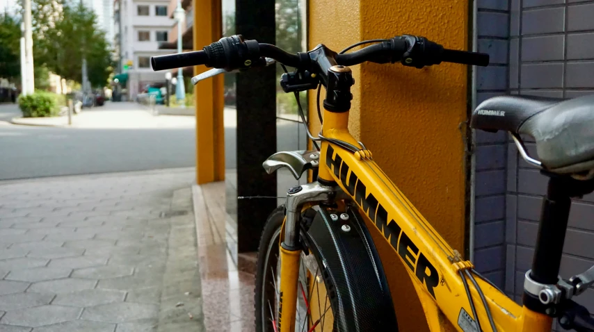 there is a yellow bike parked on the street