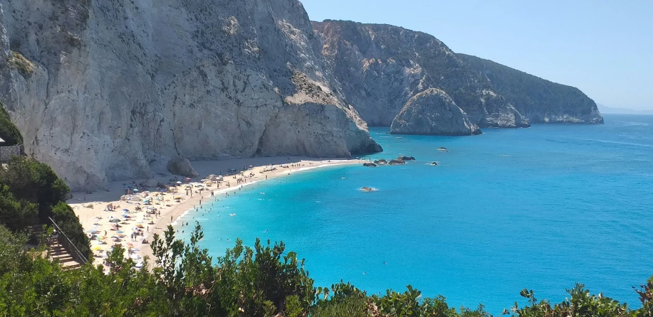 a cliff face that has beach and water near it