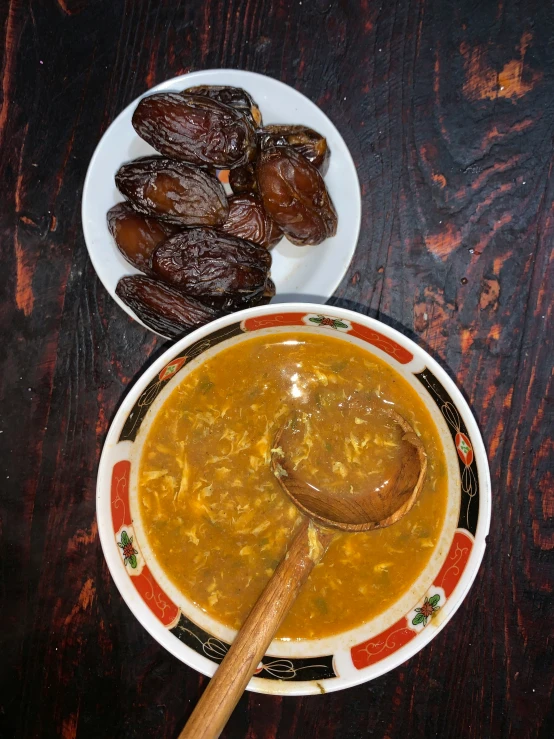 a plate full of yellow soup next to some raisins