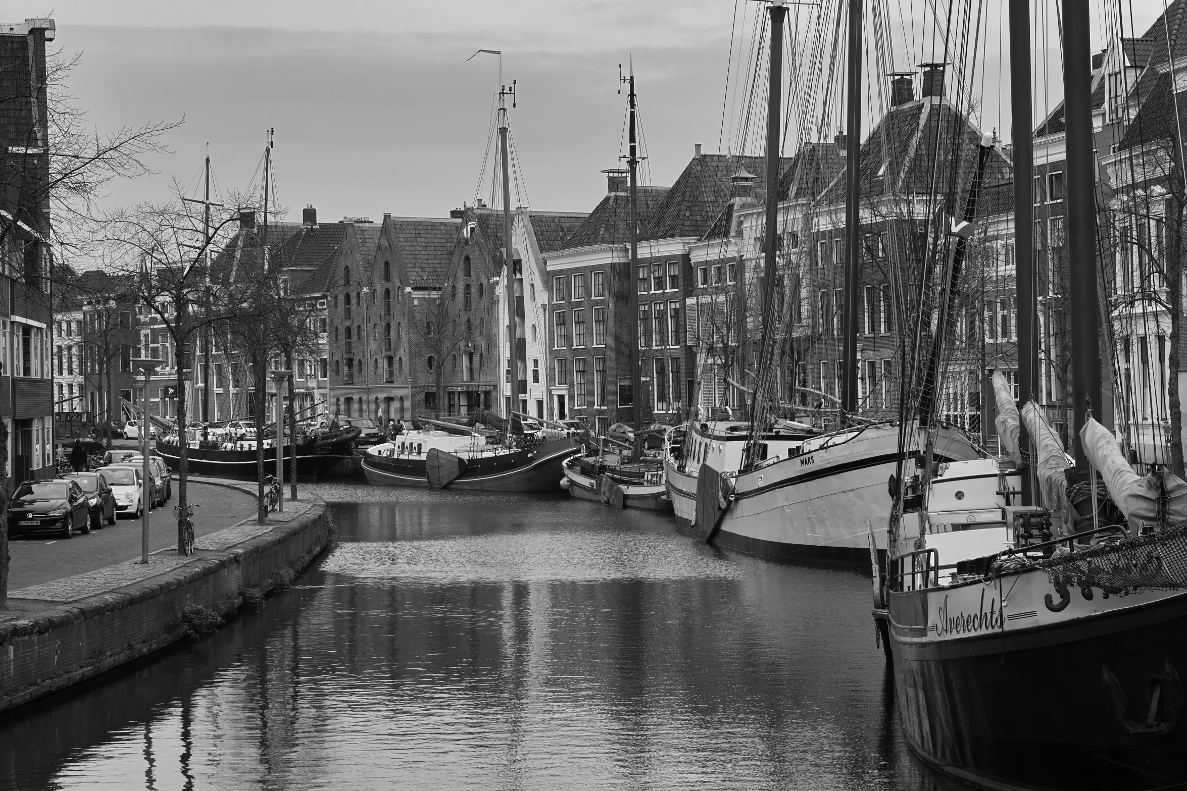 black and white pograph of boats docked in a canal