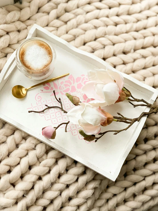 a tray with a spoon on top of it next to an espresso mug