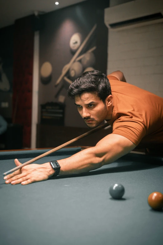 a man leaning over the top of a pool table while playing a game of pool