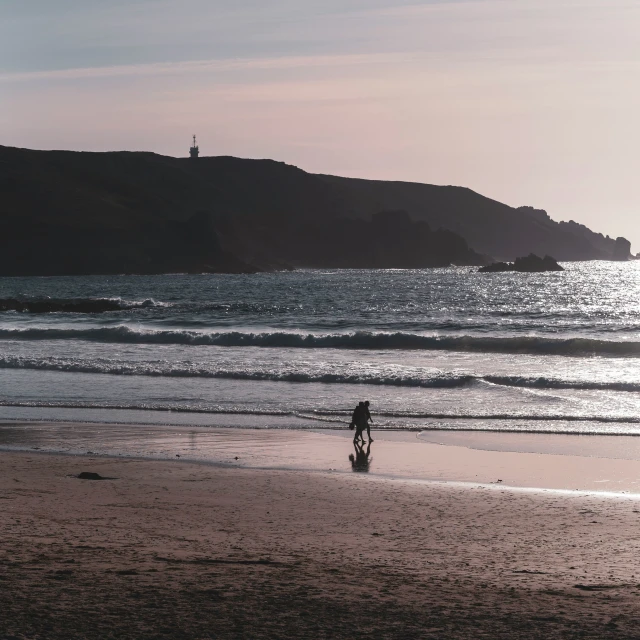 a person standing on a beach near a body of water