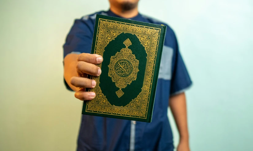 a man is holding a book that contains the symbol of sri