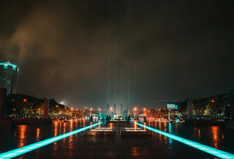 a walkway with illuminated poles going across a river