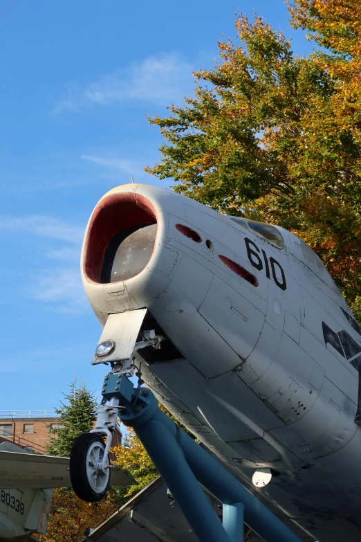 an airplane sits in a field near some buildings