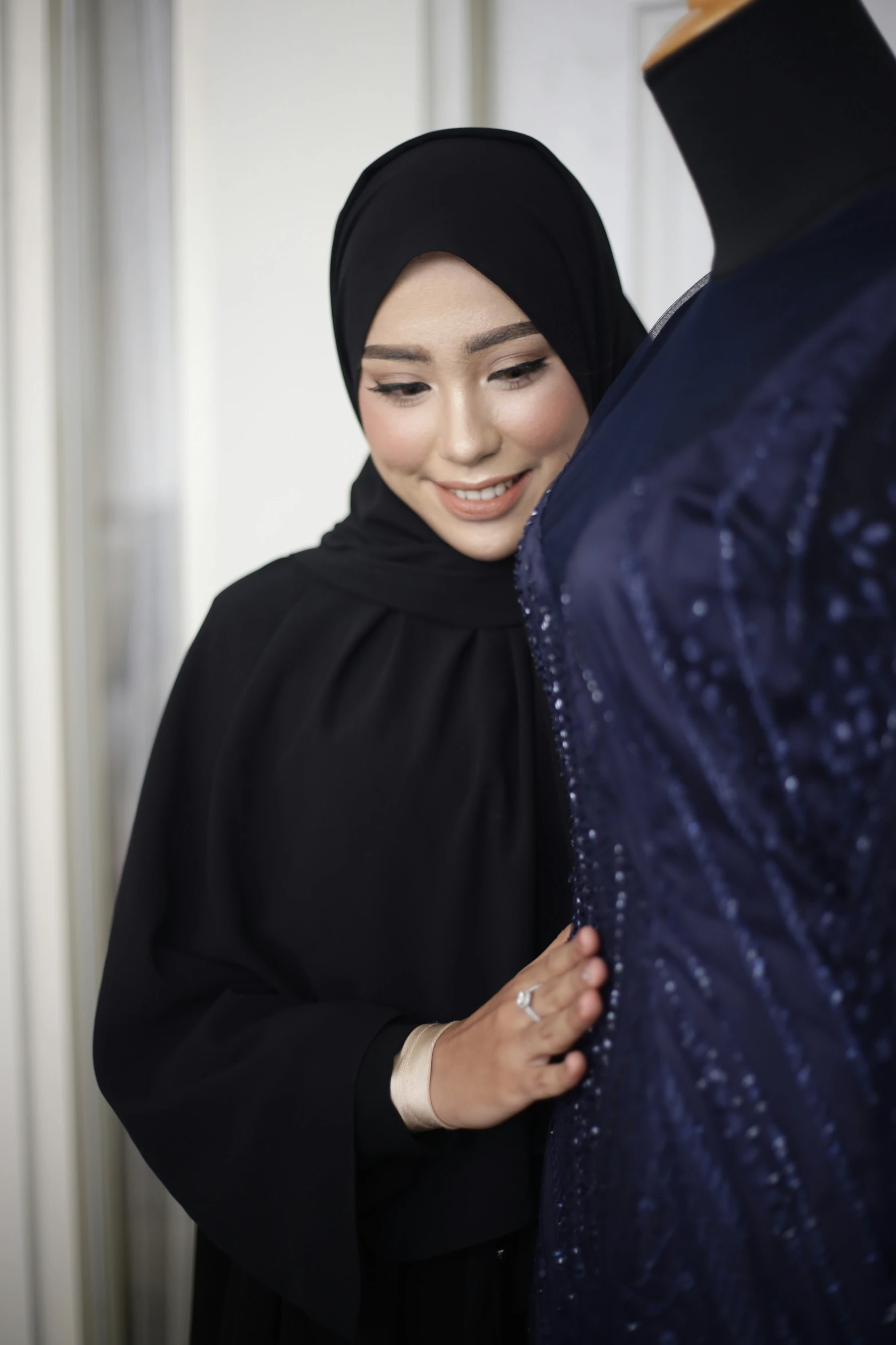 a young woman wearing a hijab and smiling
