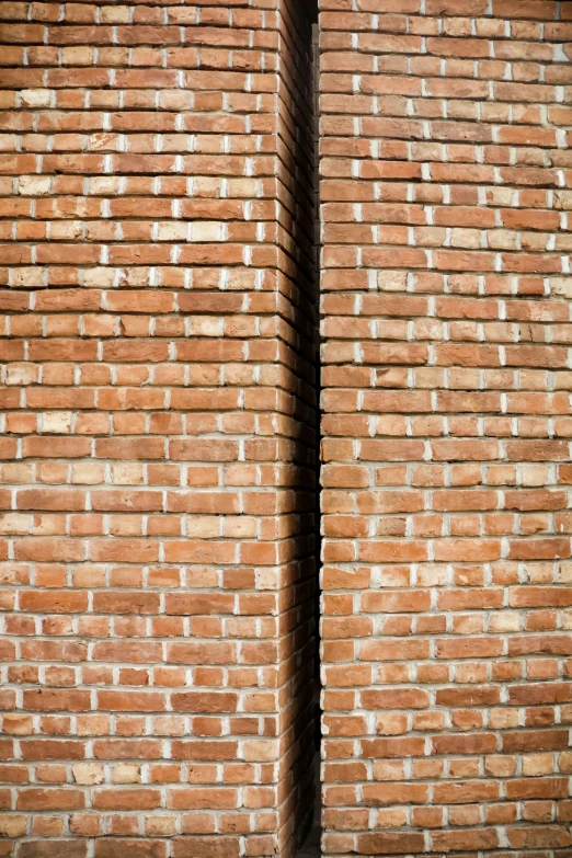 a person sitting on a bench on the sidewalk near a wall