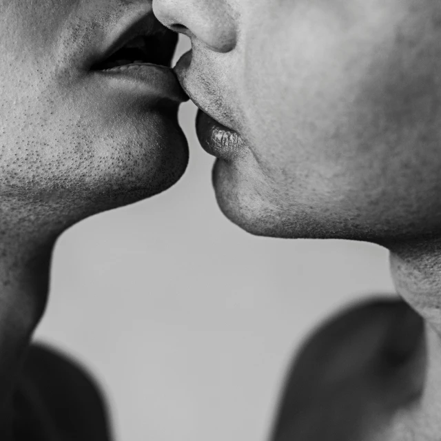 a couple of men are kissing each other