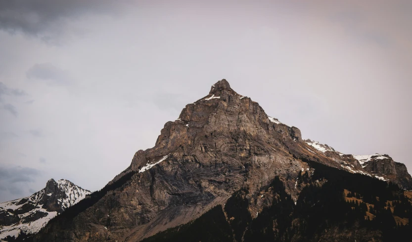 a snow covered mountain with trees around it