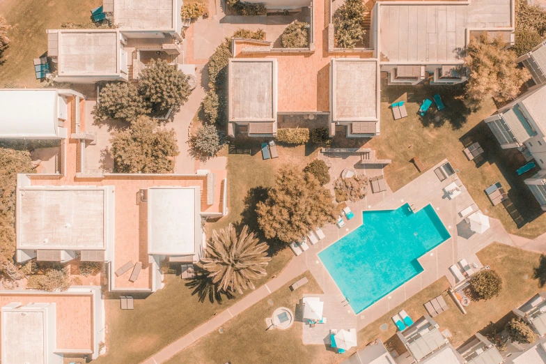 an aerial view of a pool surrounded by several buildings