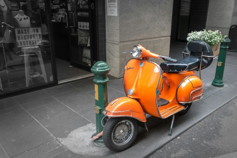 an orange motorcycle parked next to a parking meter