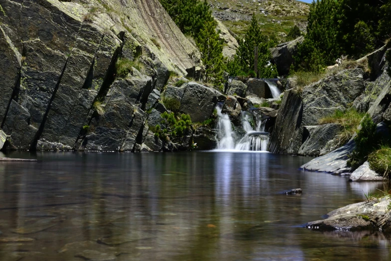 the rocks are behind a waterfall in the mountain