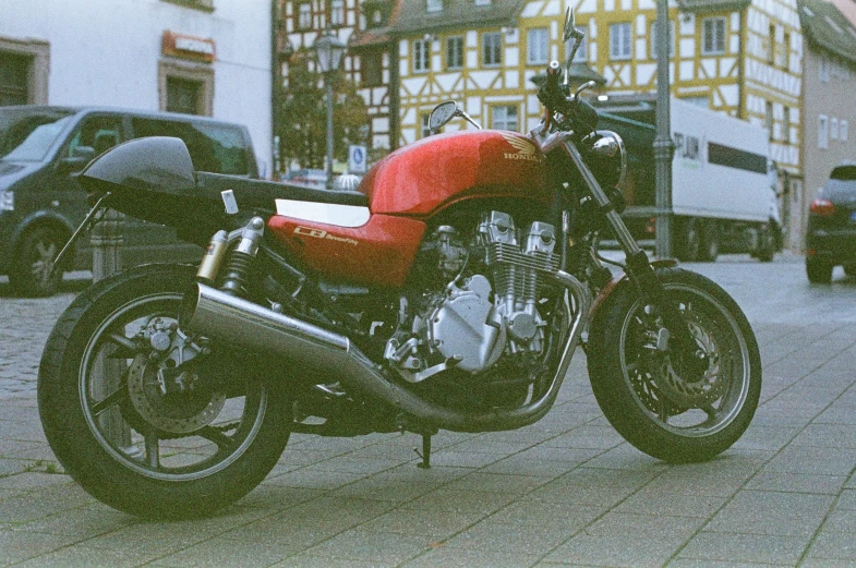 a red motorcycle is parked outside a big building