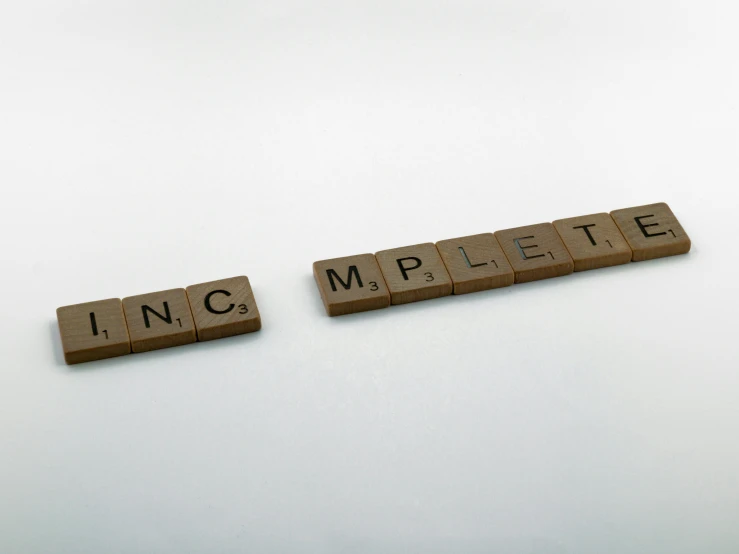 two scrabble tiles reading incompple and incompples