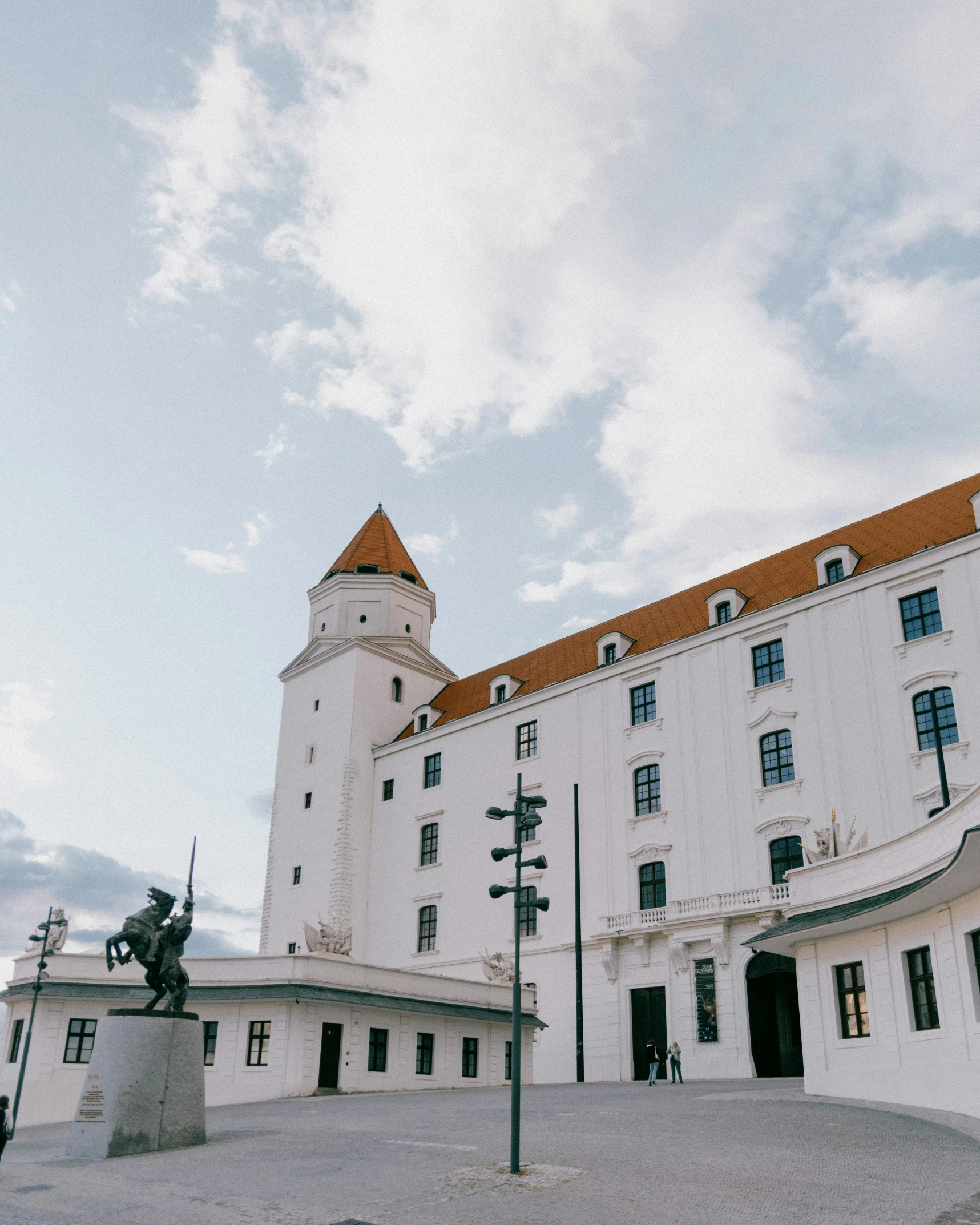 the exterior of a white building that has a clock tower