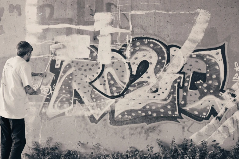 a man looking up at a wall with some graffitti