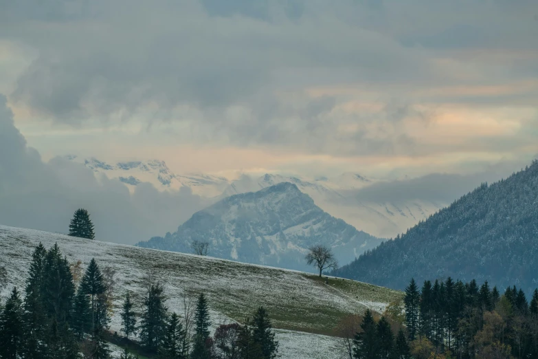 there is snow on the ground and a hill below