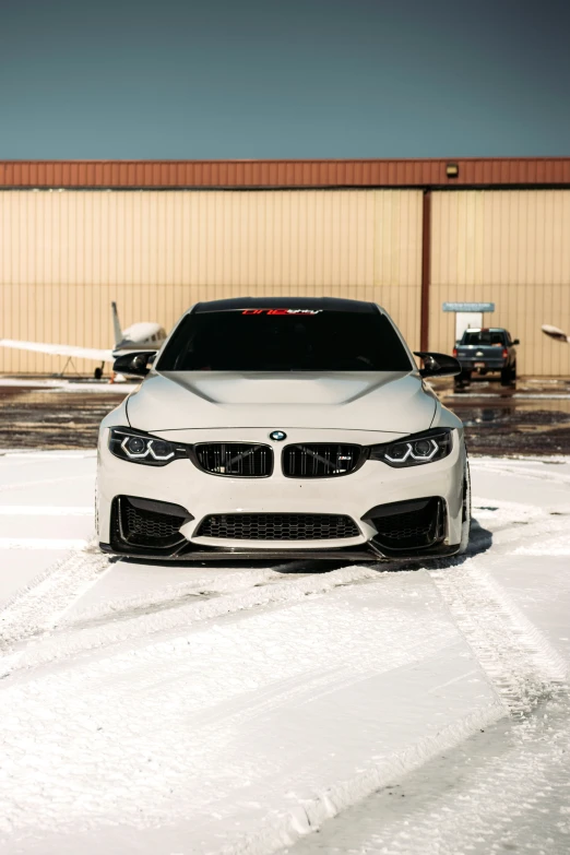a bmw car is parked outside on snow