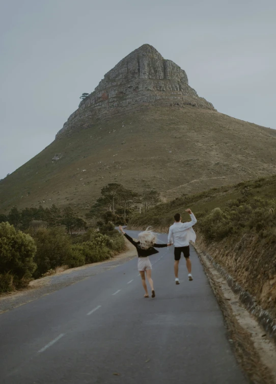 two people walking down the middle of a road