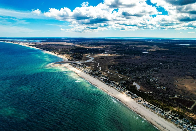 the ocean next to the shore under a partly cloudy sky