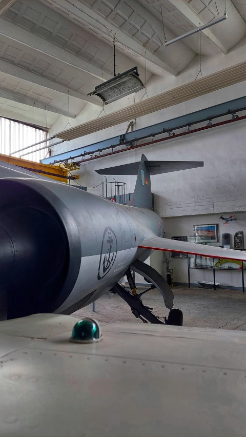 an airplane sitting inside of a garage next to a shelf