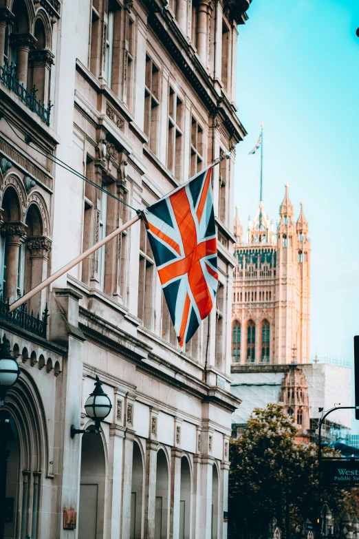 a union jack flag flies in front of the palace