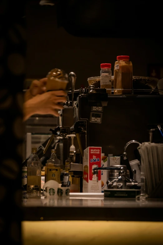 a person is serving coffee from a machine