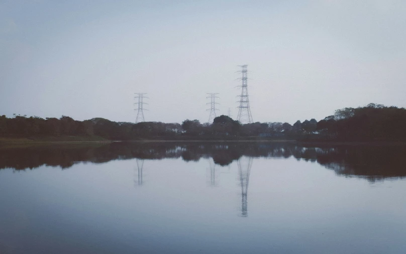 an image of trees and water with phone towers