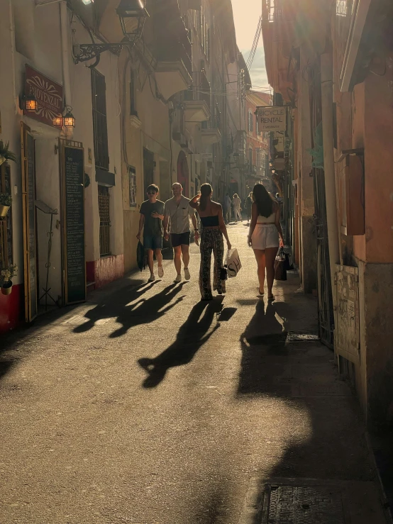 a group of people walking along a cobblestone street