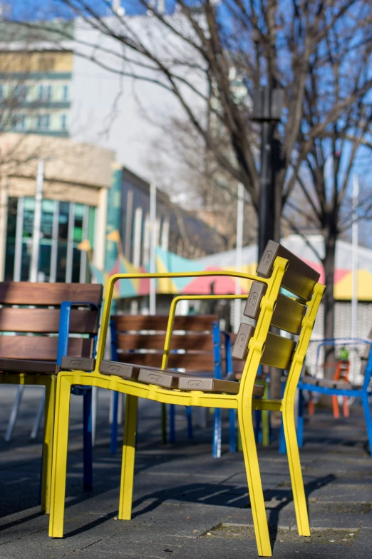 there are many colored chairs sitting by the table