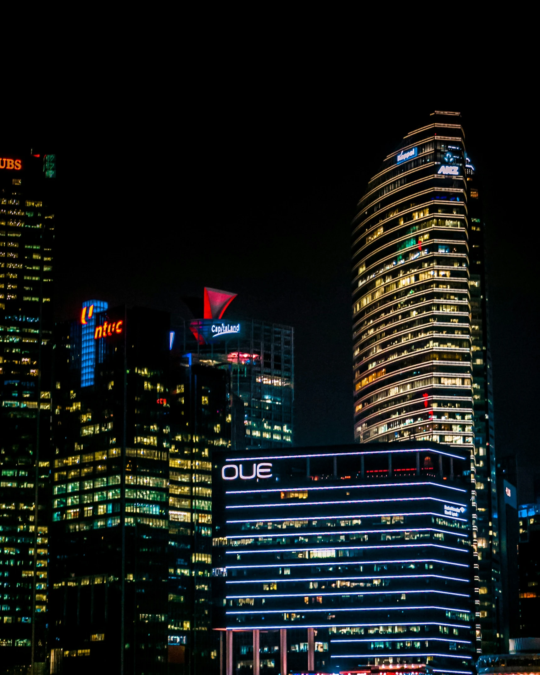 several tall buildings in the dark and lit up