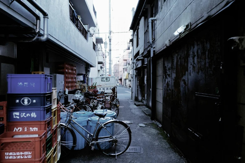 a narrow alley in an asian city with several boxes piled on the side