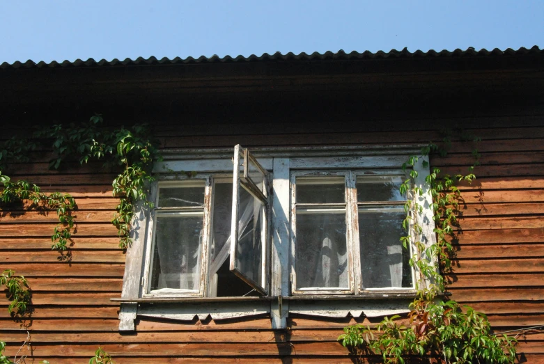 a white window and curtain on the side of a building